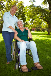 caregiver and senior woman on a wheelchair smiling